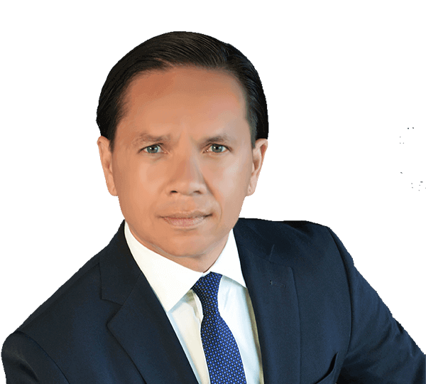Studio portrait of a man in a dark suit and blue tie against a white background