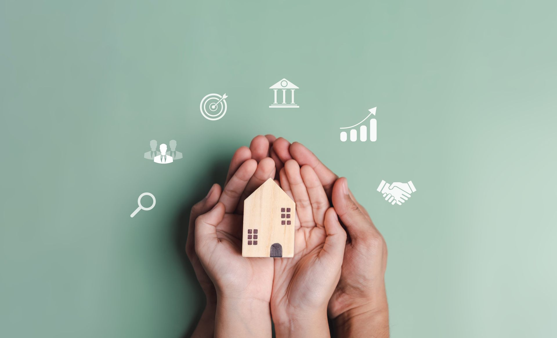 Hands cupping a small house model on a green background with white real estate icons around it