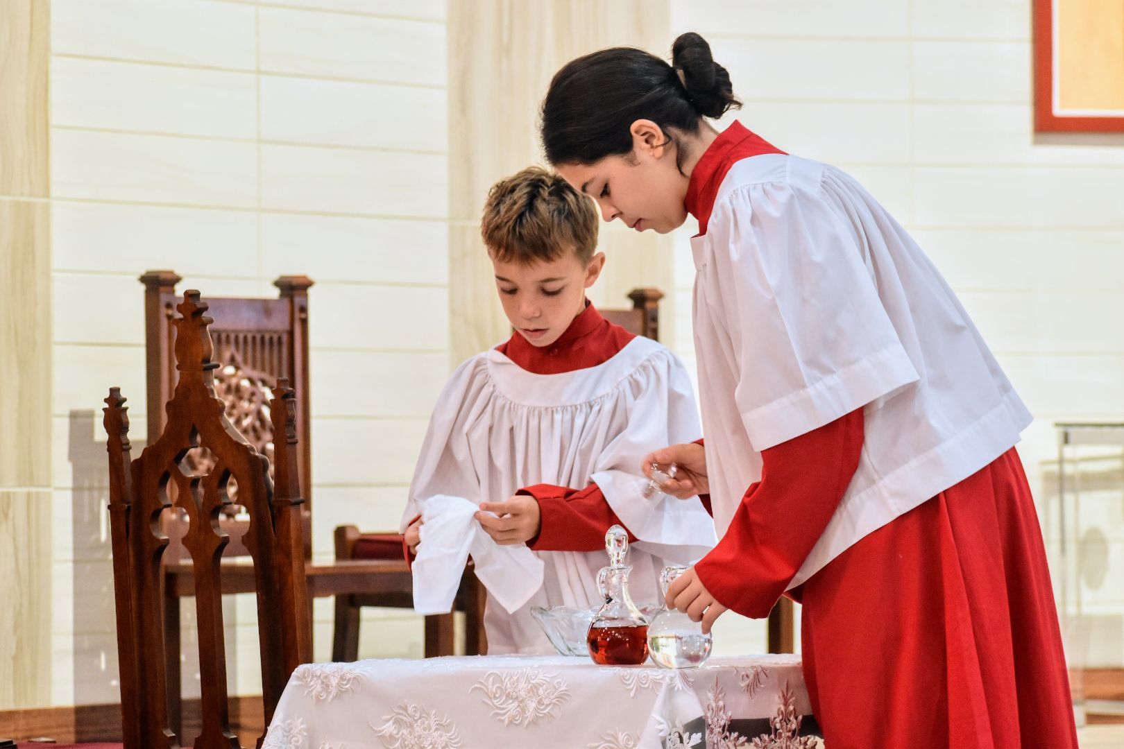 Woman serving wine to boy at a church altar during a ceremony