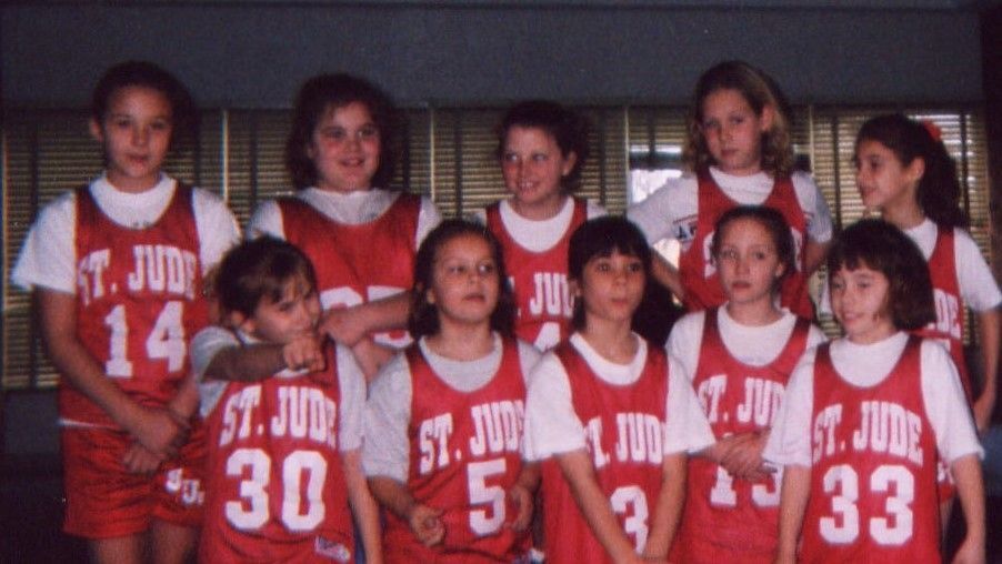 Youth basketball team in red St. Jude jerseys posing together for a group photo