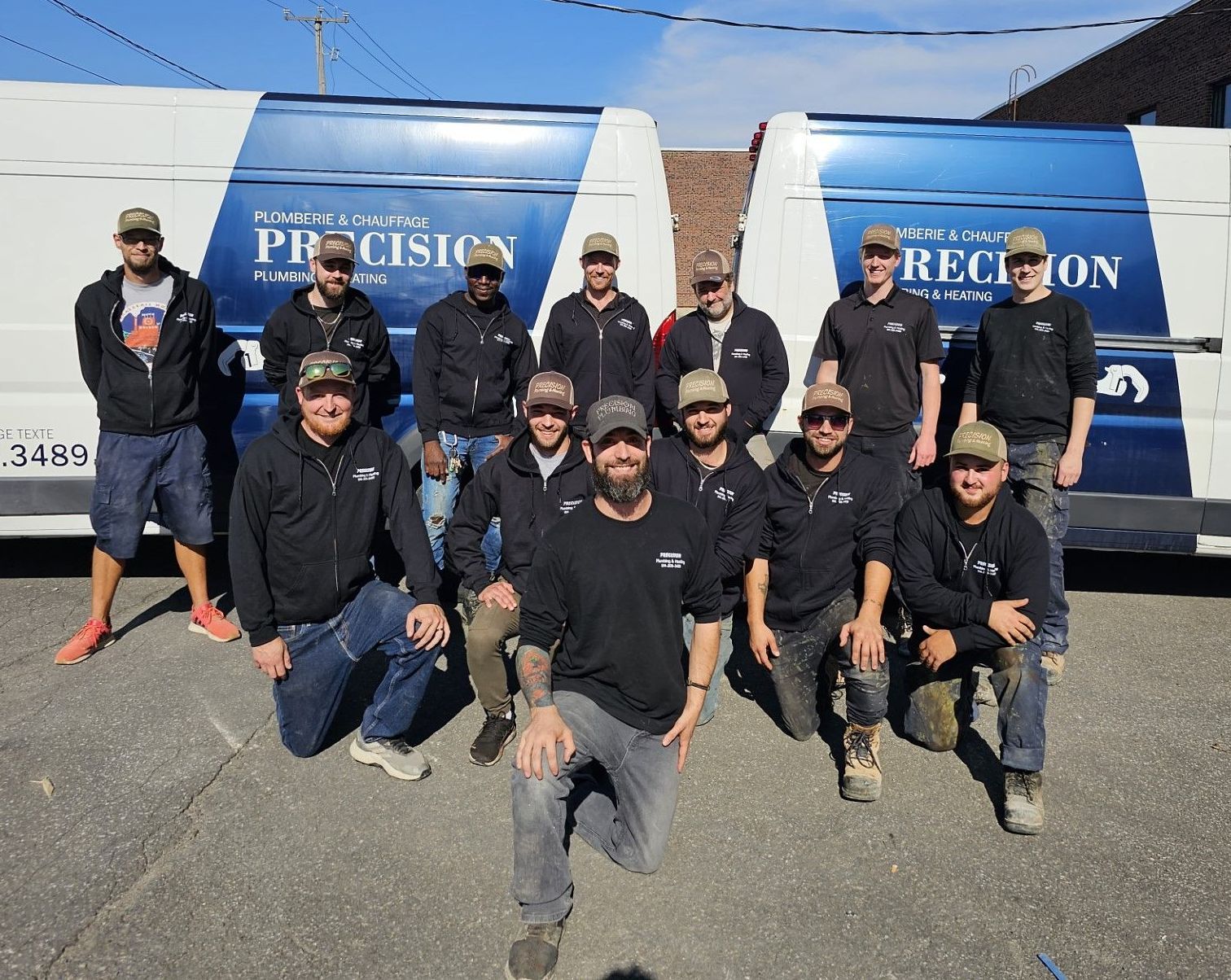 Un groupe d'hommes pose pour une photo devant des fourgonnettes de précision.