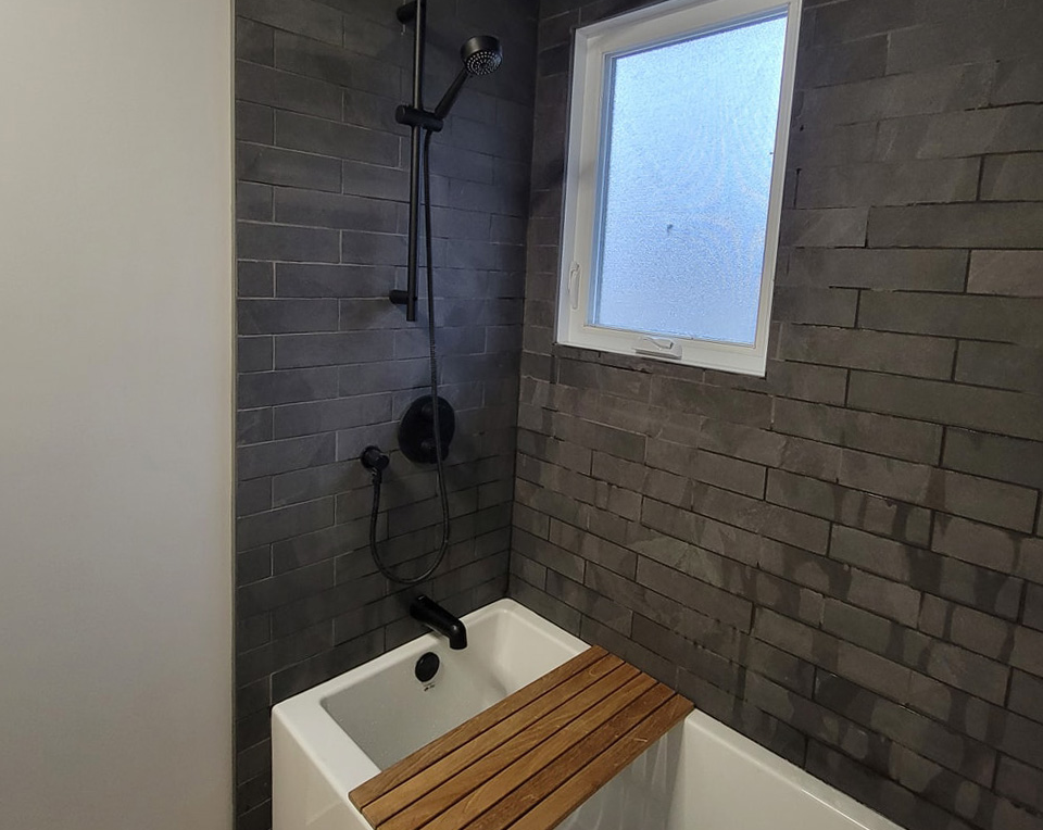 Une salle de bain avec baignoire, douche et fenêtre.