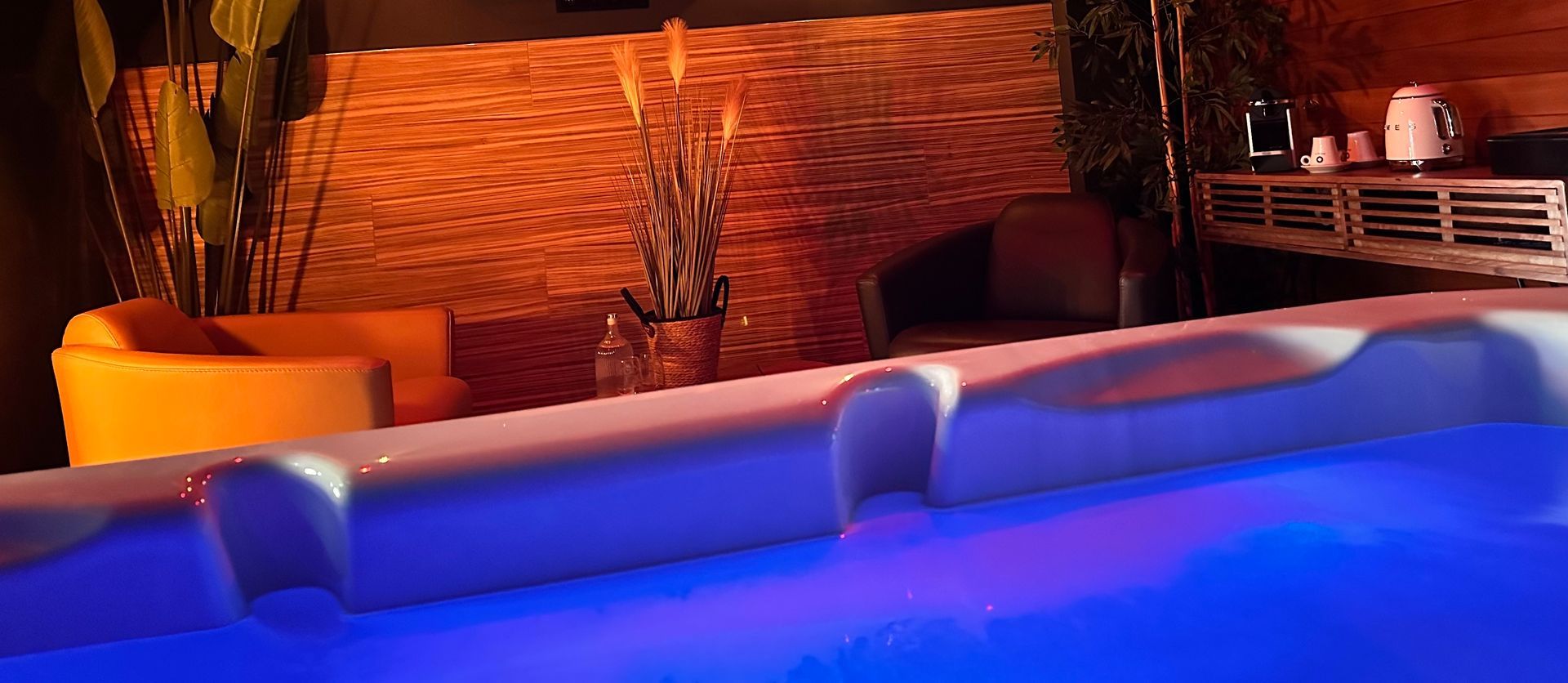 Warmly lit hot tub with blue water in an indoor spa lounge
