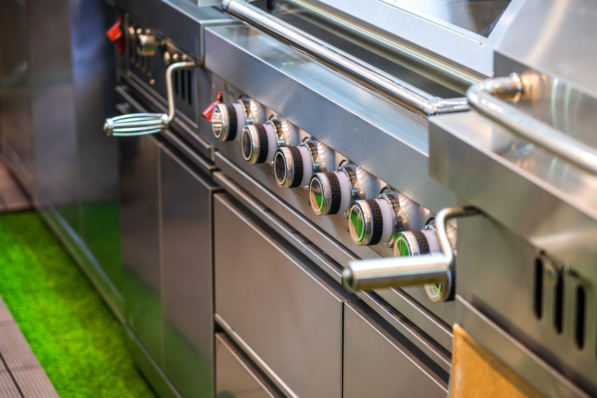 Stainless steel gas stove with control knobs and oven door, shown close-up in a kitchen