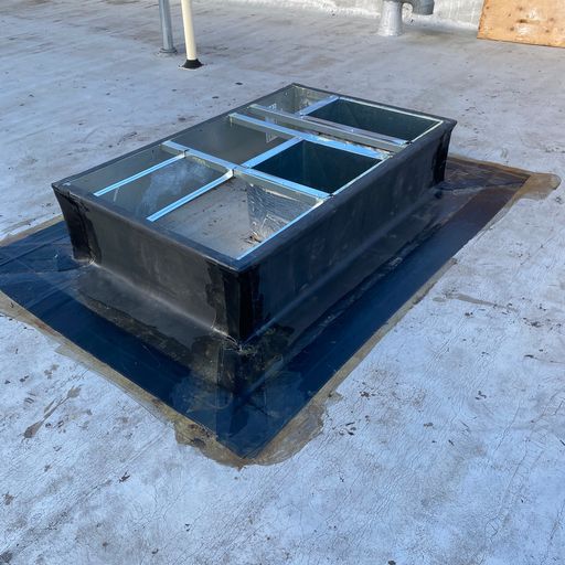 A metal box is sitting on top of a roof.
