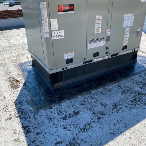 A trane air conditioner is sitting on top of a roof