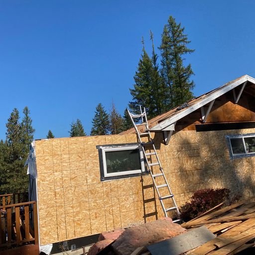 A ladder is sitting on top of a house under construction.