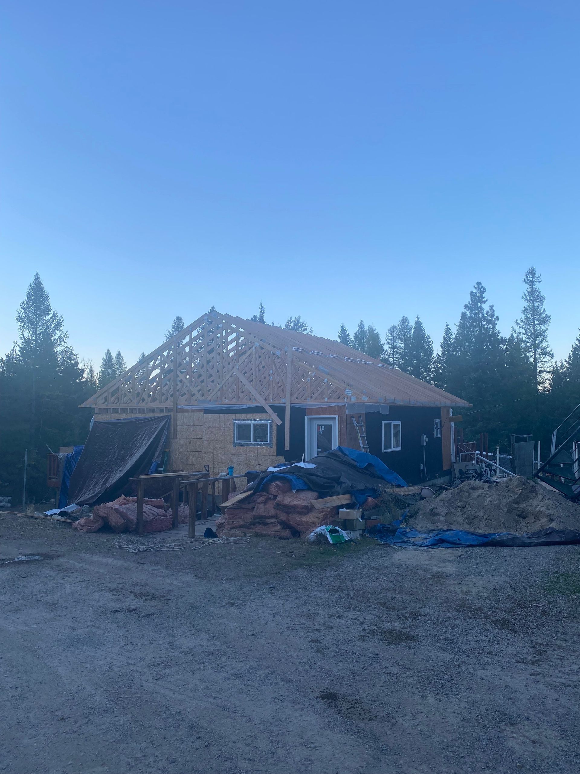 A house is being built in the middle of a dirt field.