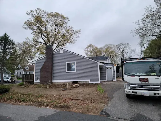 A white truck is parked in front of a house.