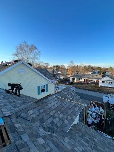 A man is working on the roof of a house.