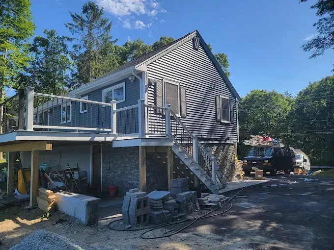 A house with a large deck and stairs is being built.