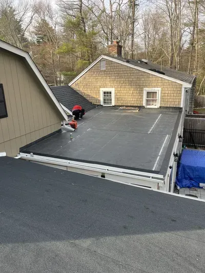 A man is working on the roof of a house.