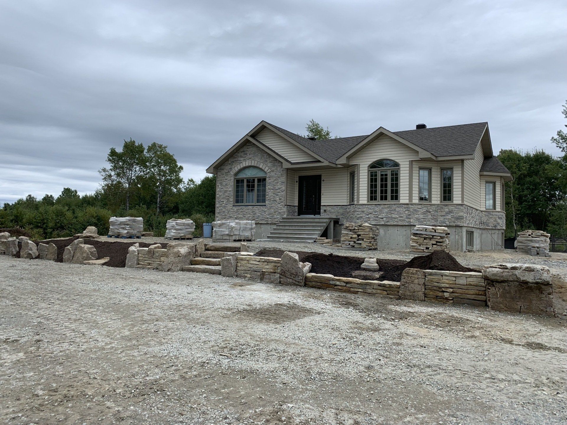 Une grande maison avec beaucoup de gravier devant.
