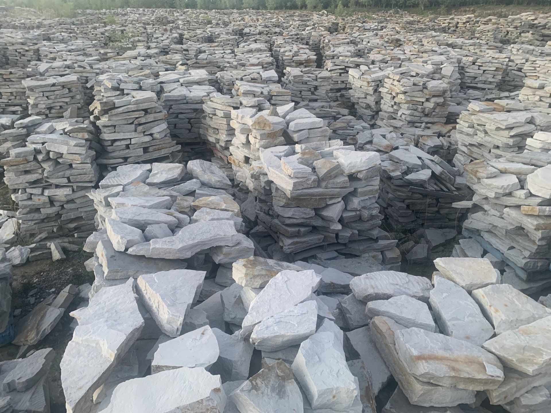 Des piles de pierres plates grises dans un champ rocailleux en plein air