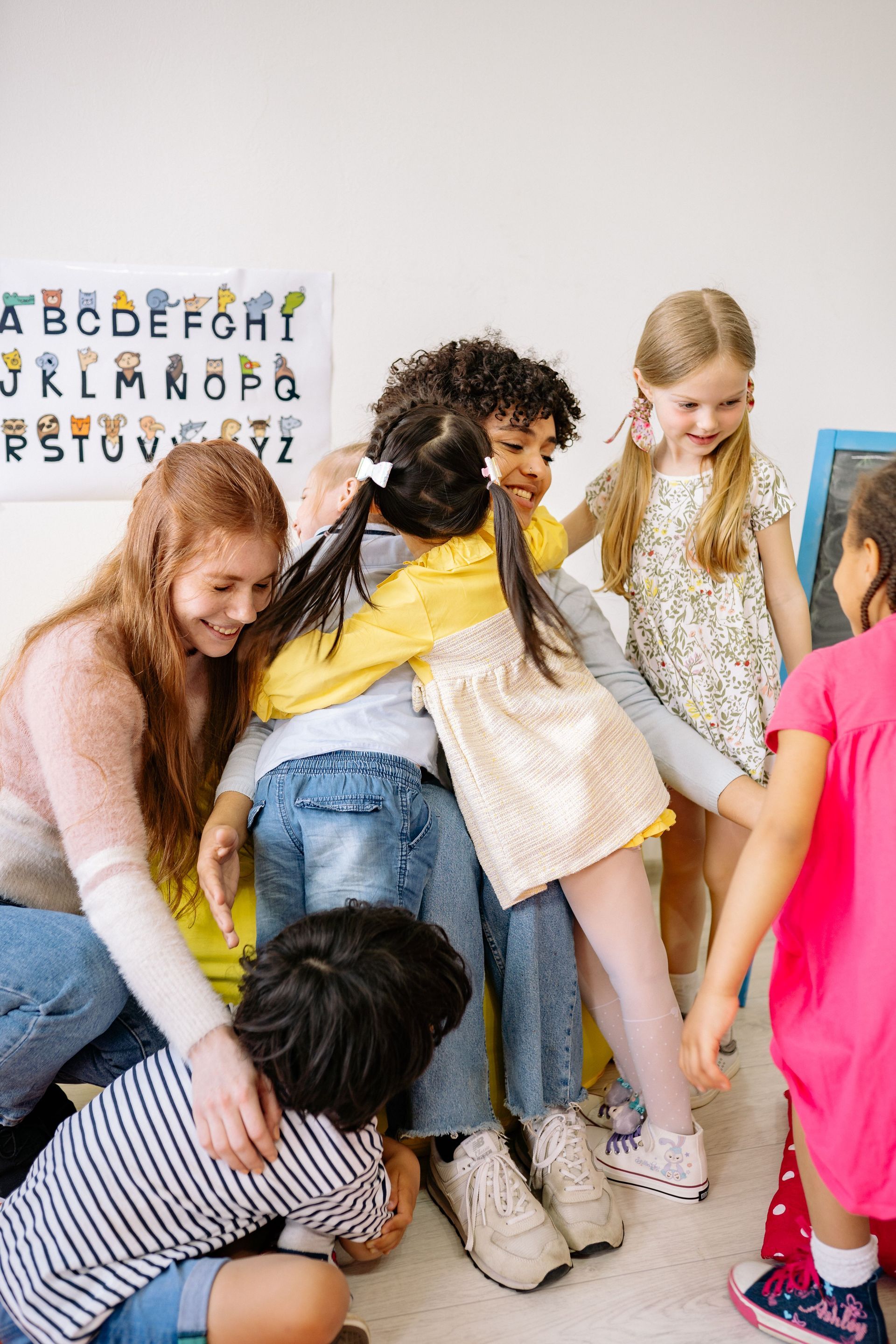 kids hugging their teacher