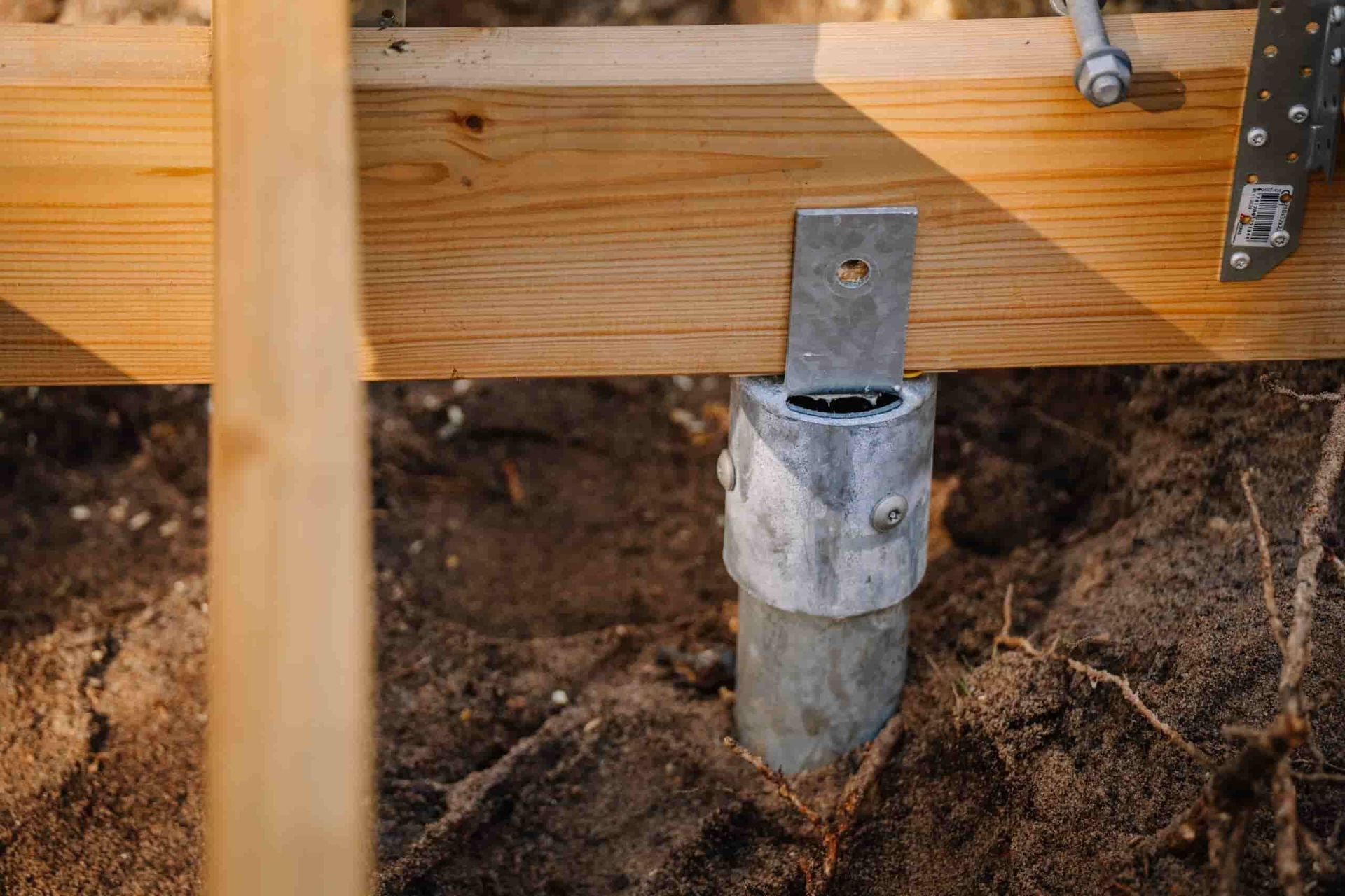A Close Up of a Metal Screw in the Ground Under a Wooden Deck — Q-Pile Foundations in Coolum Beach, QLD