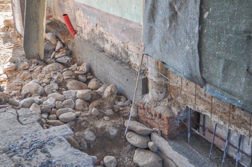 A Pile of Rocks is Sitting Next to a Brick Wall — Q-Pile Foundations in Caloundra, QLD