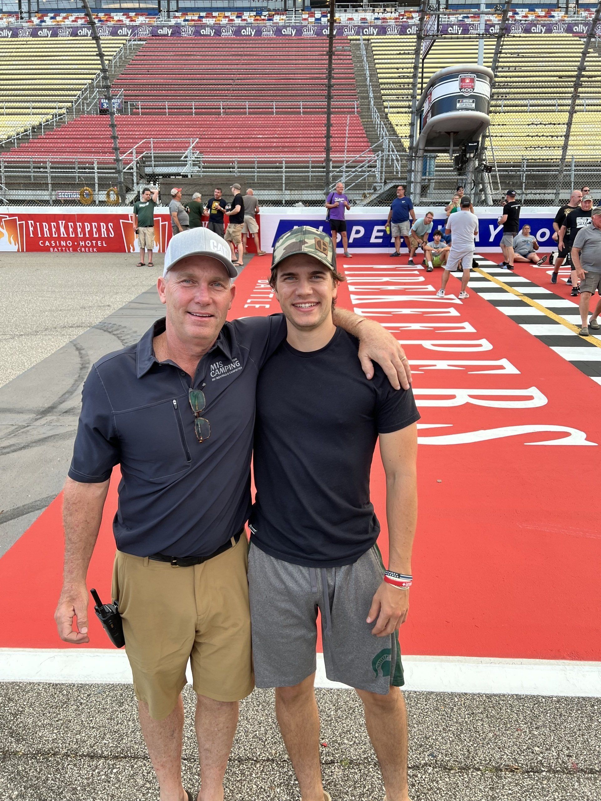 Two men standing next to each other on a race track