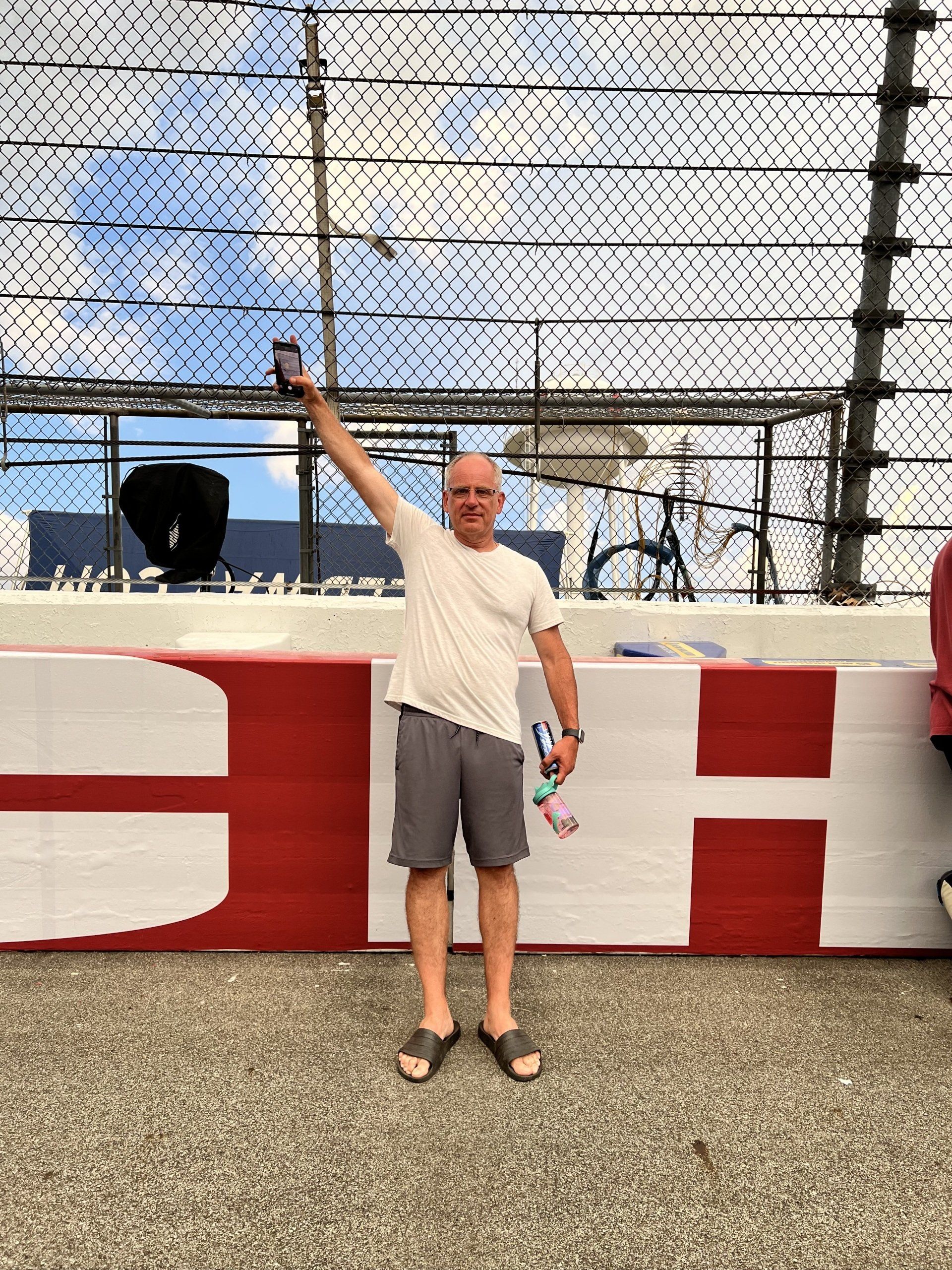A man stands in front of a sign that says ch