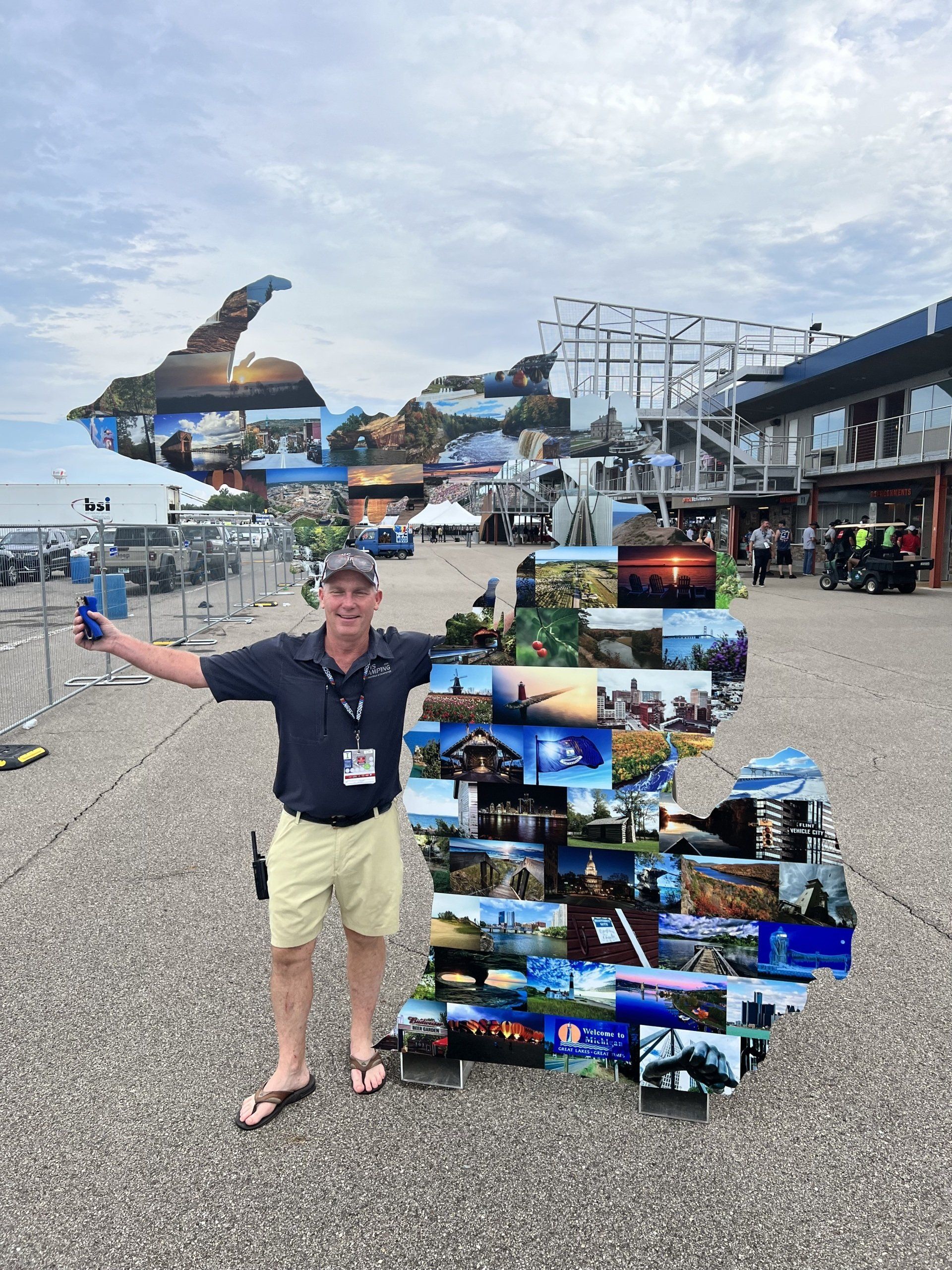 A man standing in front of a large collage of pictures