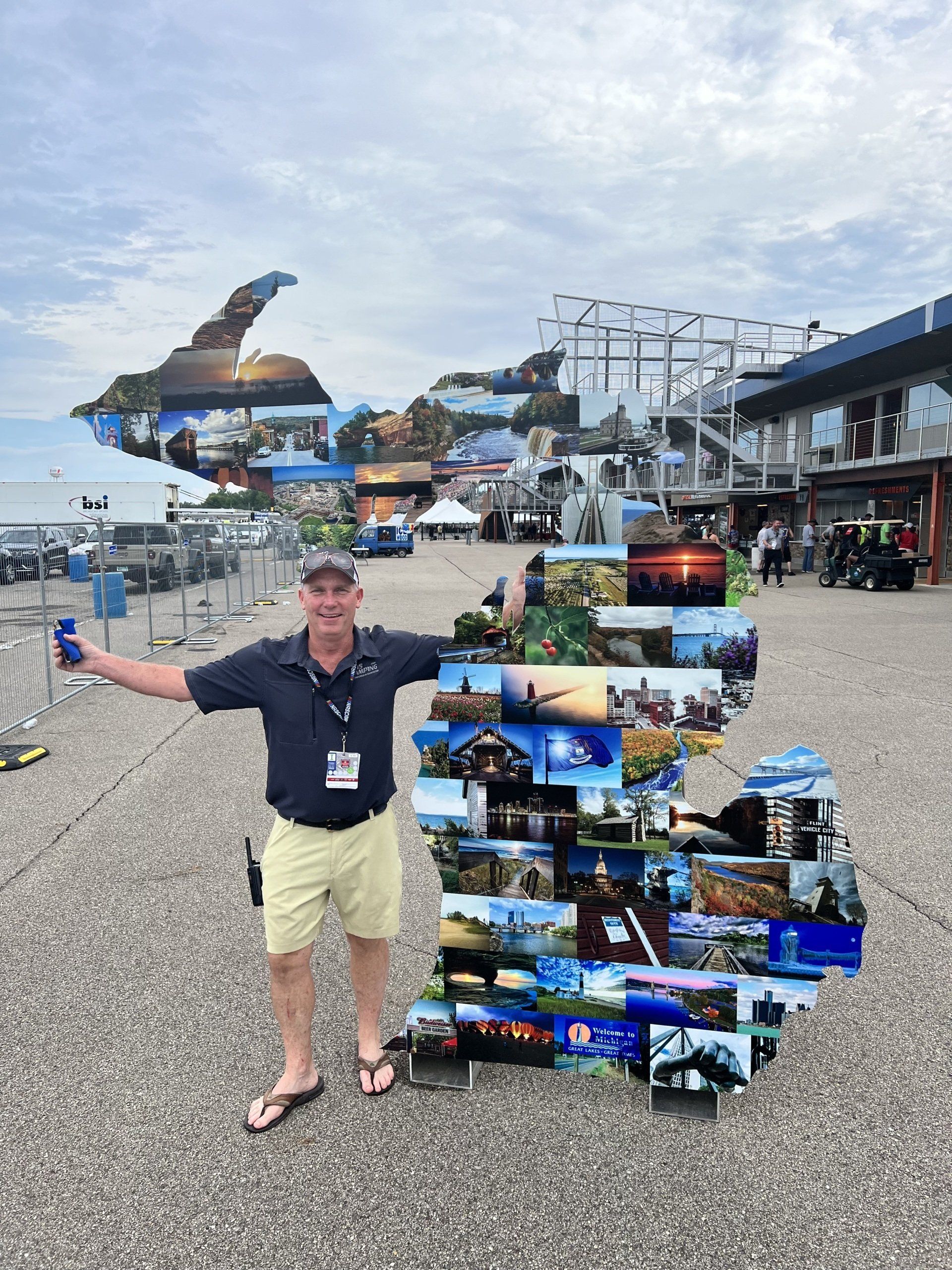 A man is standing in front of a large collage of pictures.