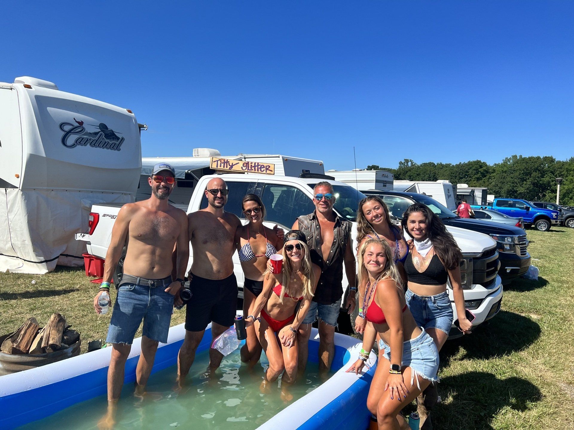 A group of people are standing in an inflatable pool.