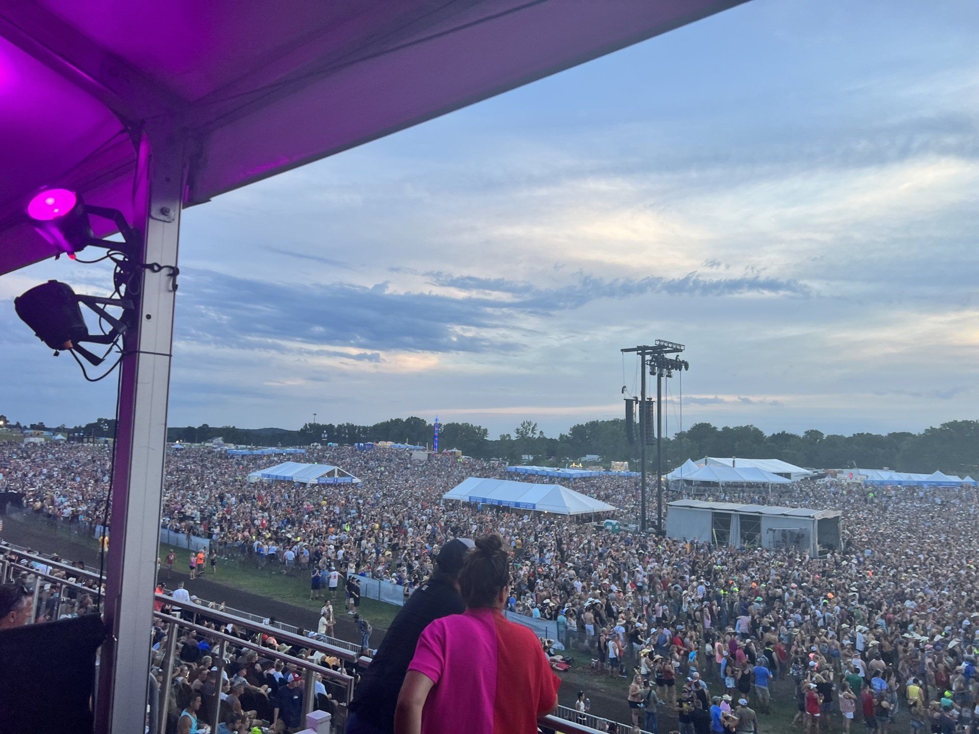 A couple of people standing in front of a crowd of people at a concert.