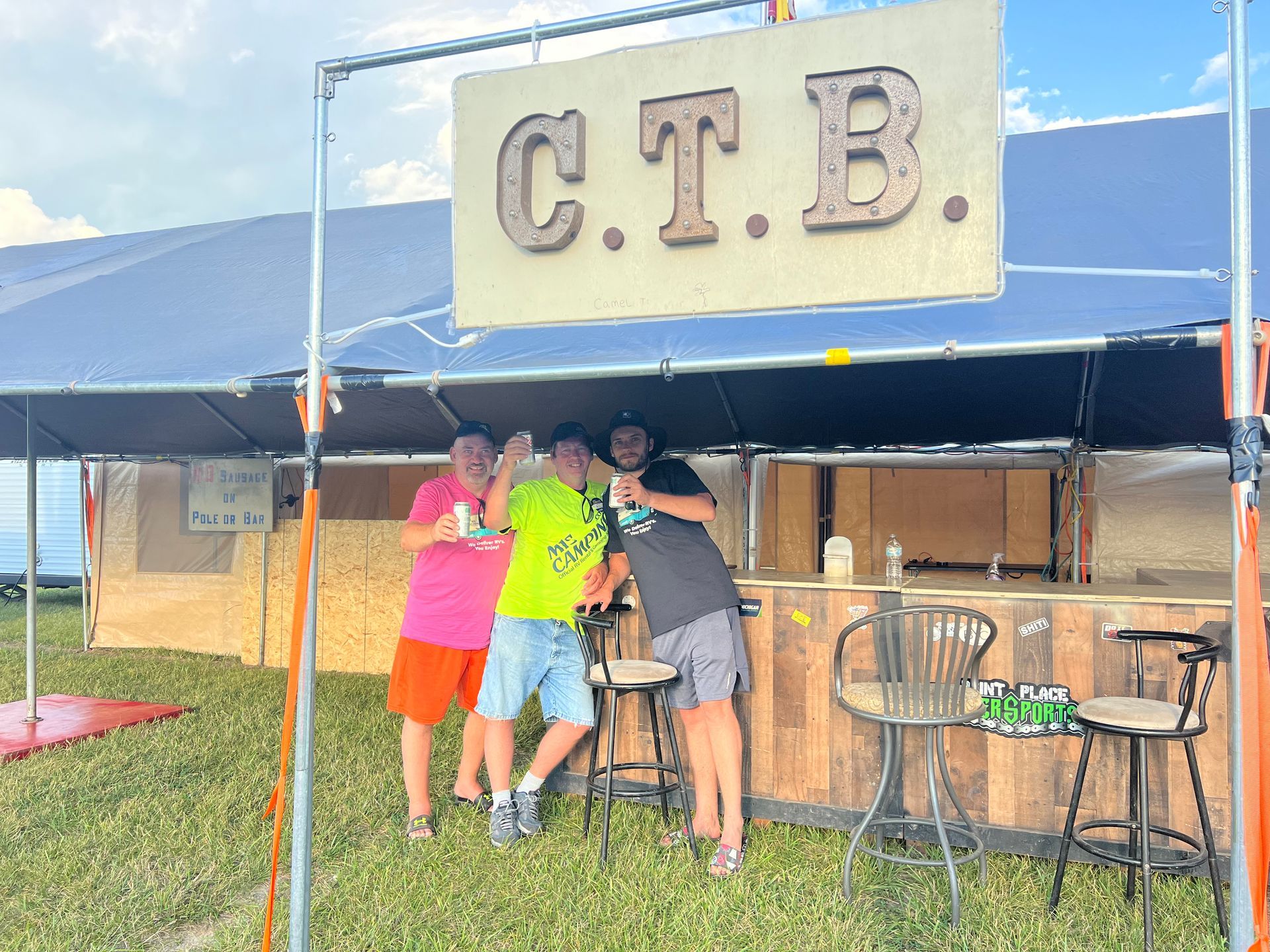 Three people at a bar under a sign that says 