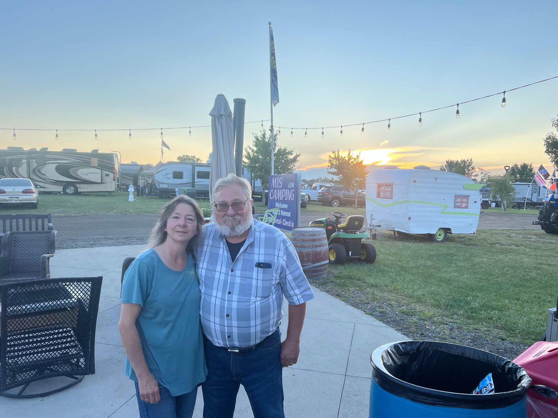 Couple standing outside, sunset in background, RV park.
