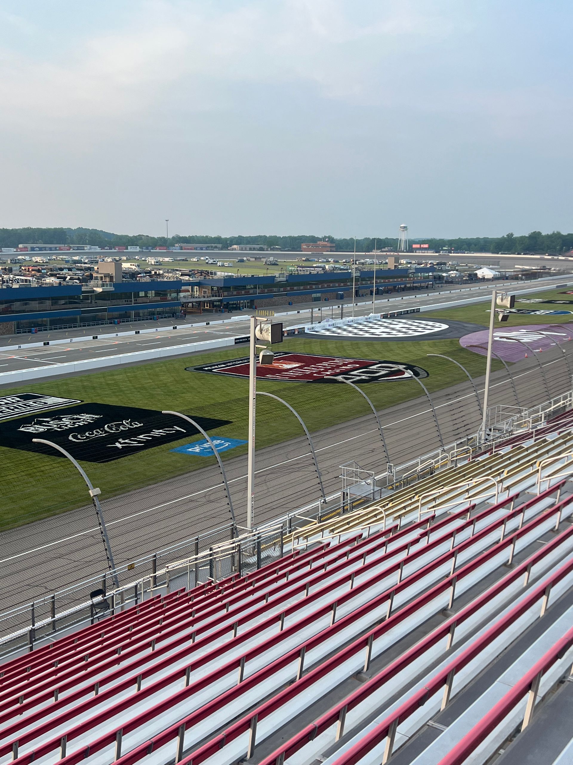 Empty racetrack grandstands overlooking the track and a large infield display.
