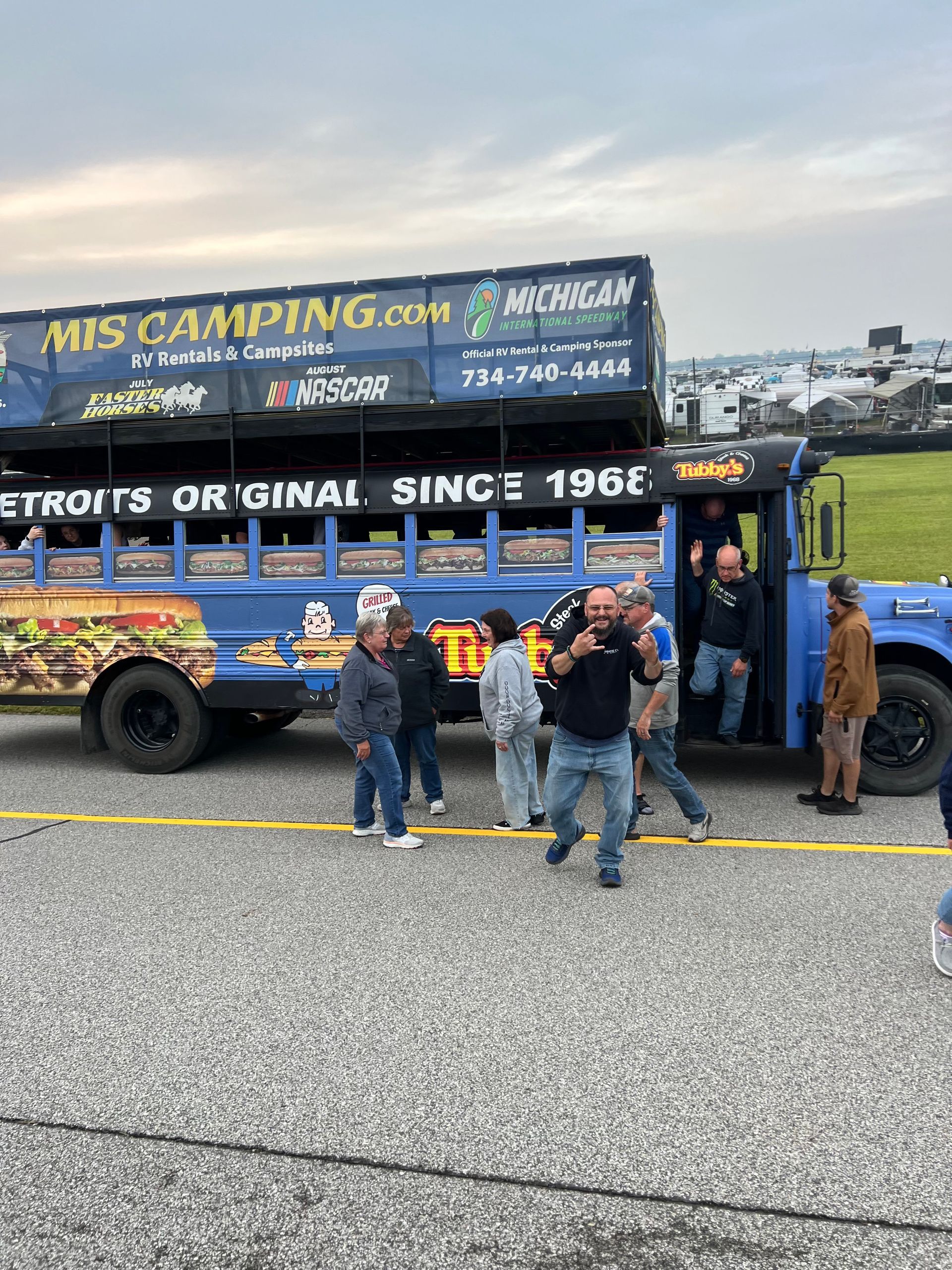 Group of people near a blue party bus with 
