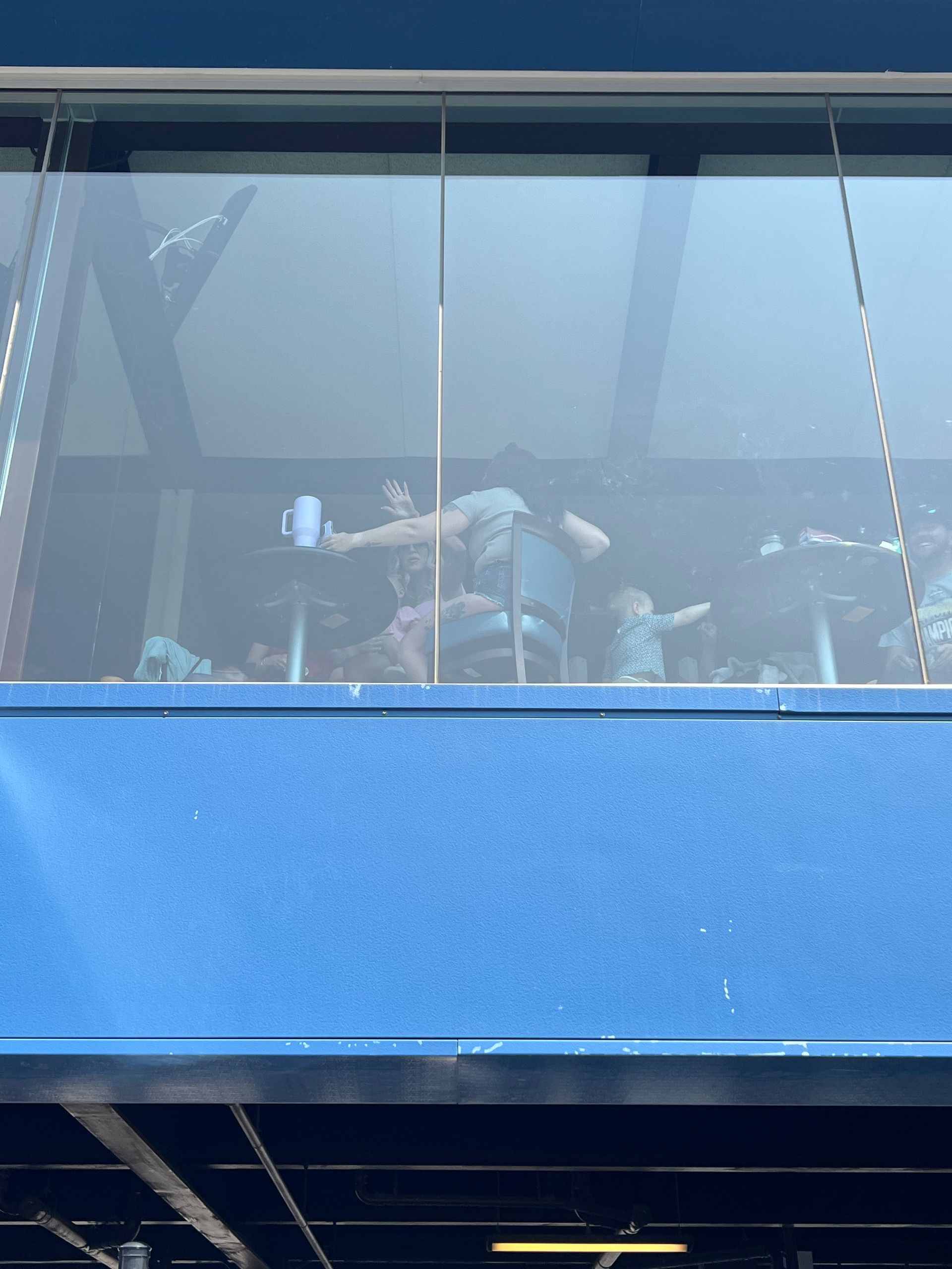 Blue building with a glass-enclosed structure, possibly a restaurant.