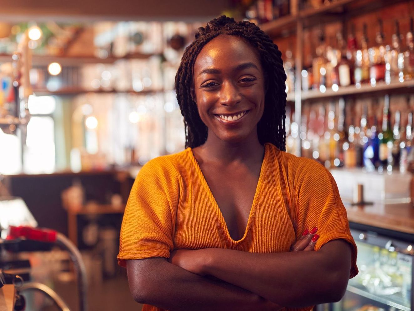 Femme souriante derrière un bar