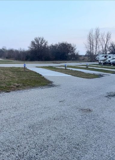 RV campsites with newly poured concrete pads and numbered hookups at Downey Carriage House RV Park