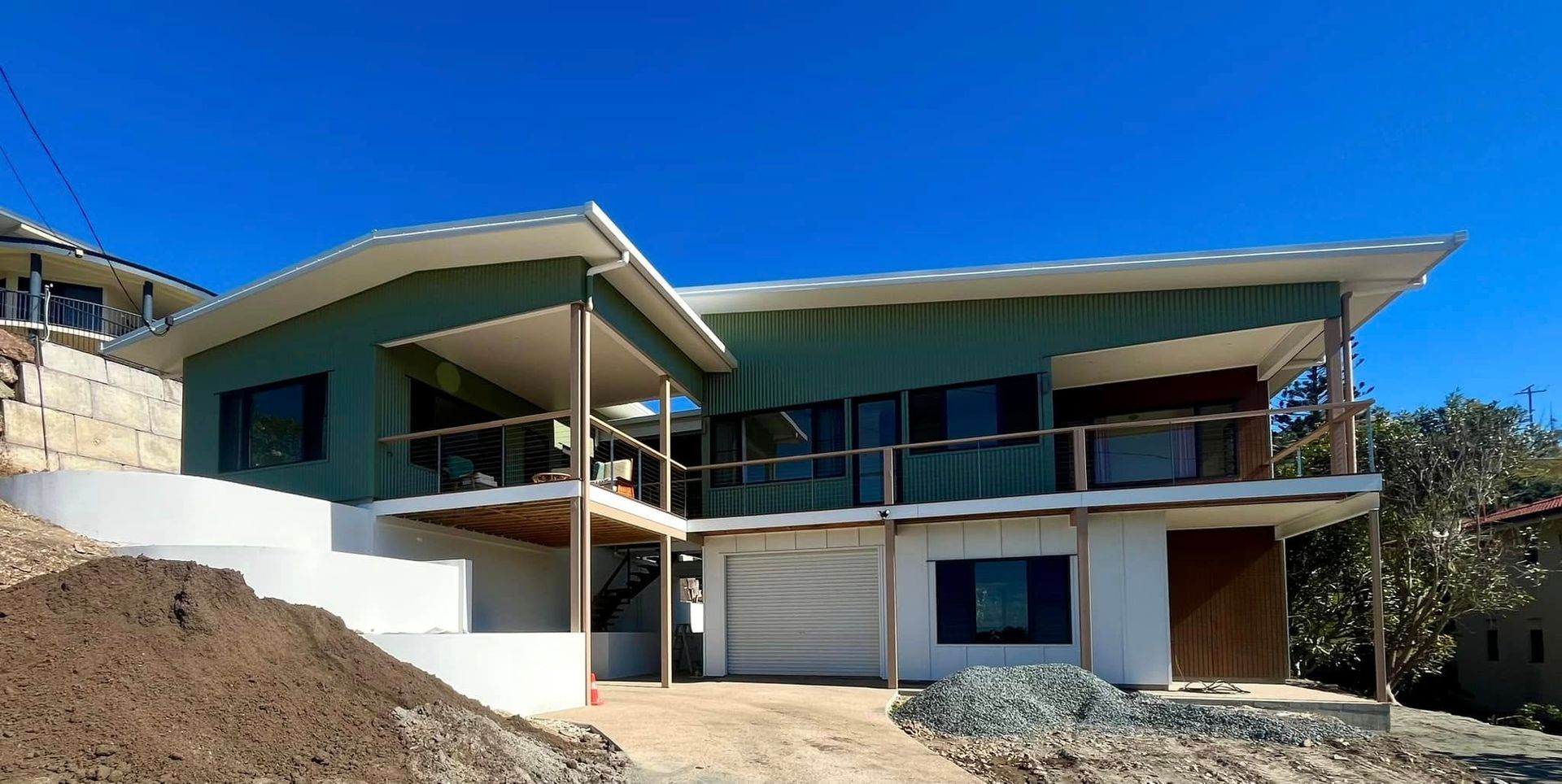 Modern Two-story House With Green Siding, White Trim, and a Blue Sky — Jones Building Group in Yeppoon, QLD