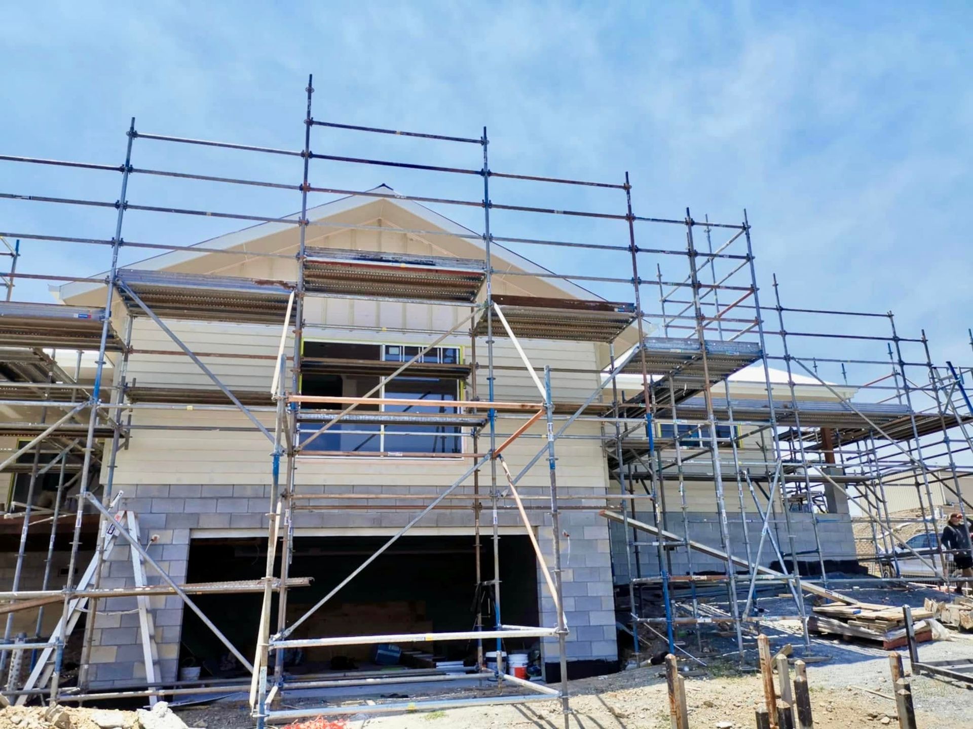 House Under Construction, Exterior With Scaffolding, Garage Door Open — Jones Building Group in Yeppoon, QLD