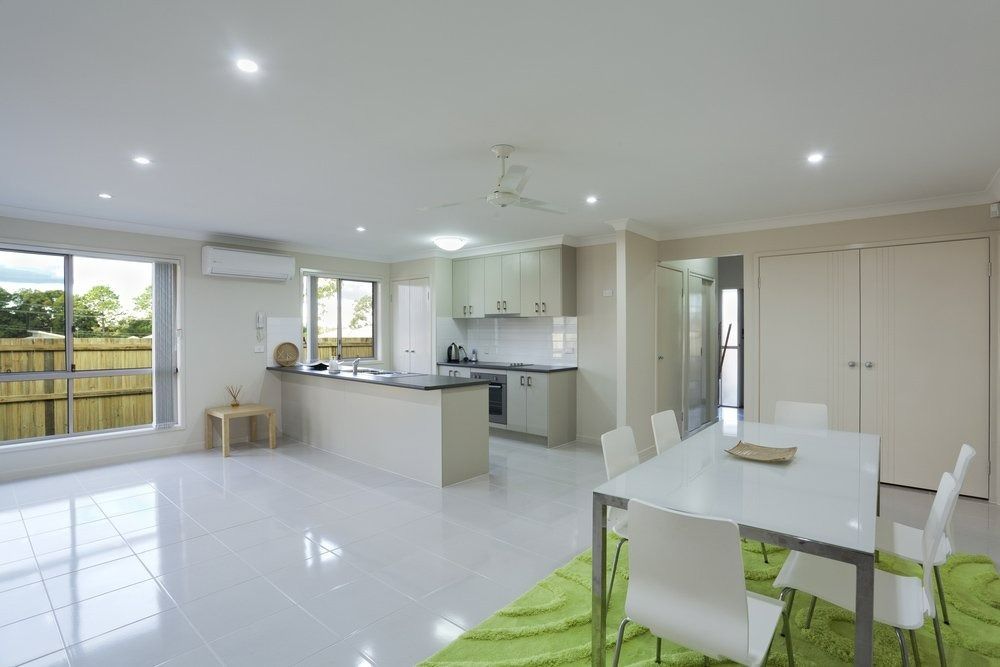 Open-plan Living Space With Kitchen, Dining Area, and Large Windows — Jones Building Group in Yeppoon, QLD