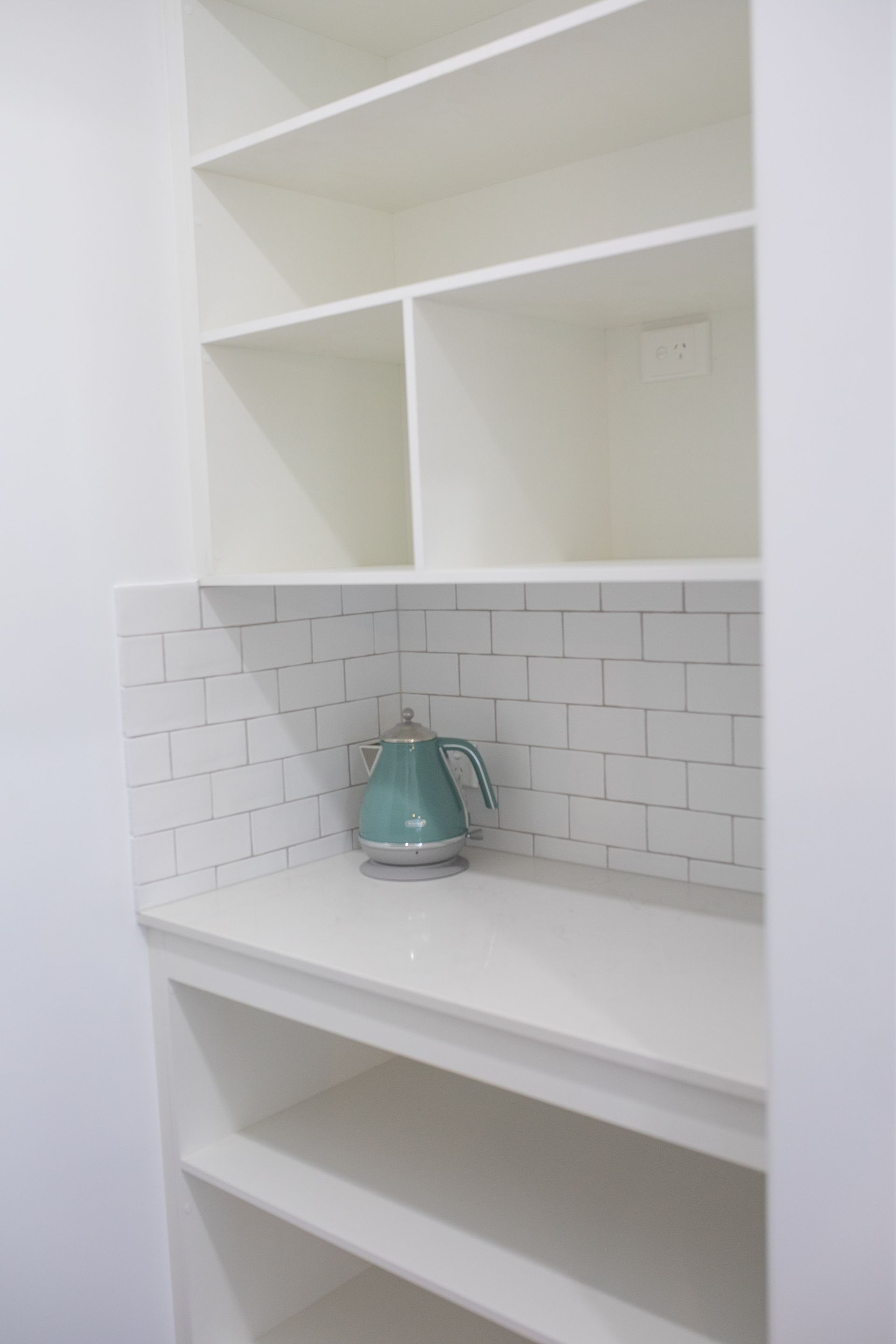 White Built-in Shelves With a Teal Teapot on a Tiled Counter — Jones Building Group in Yeppoon, QLD