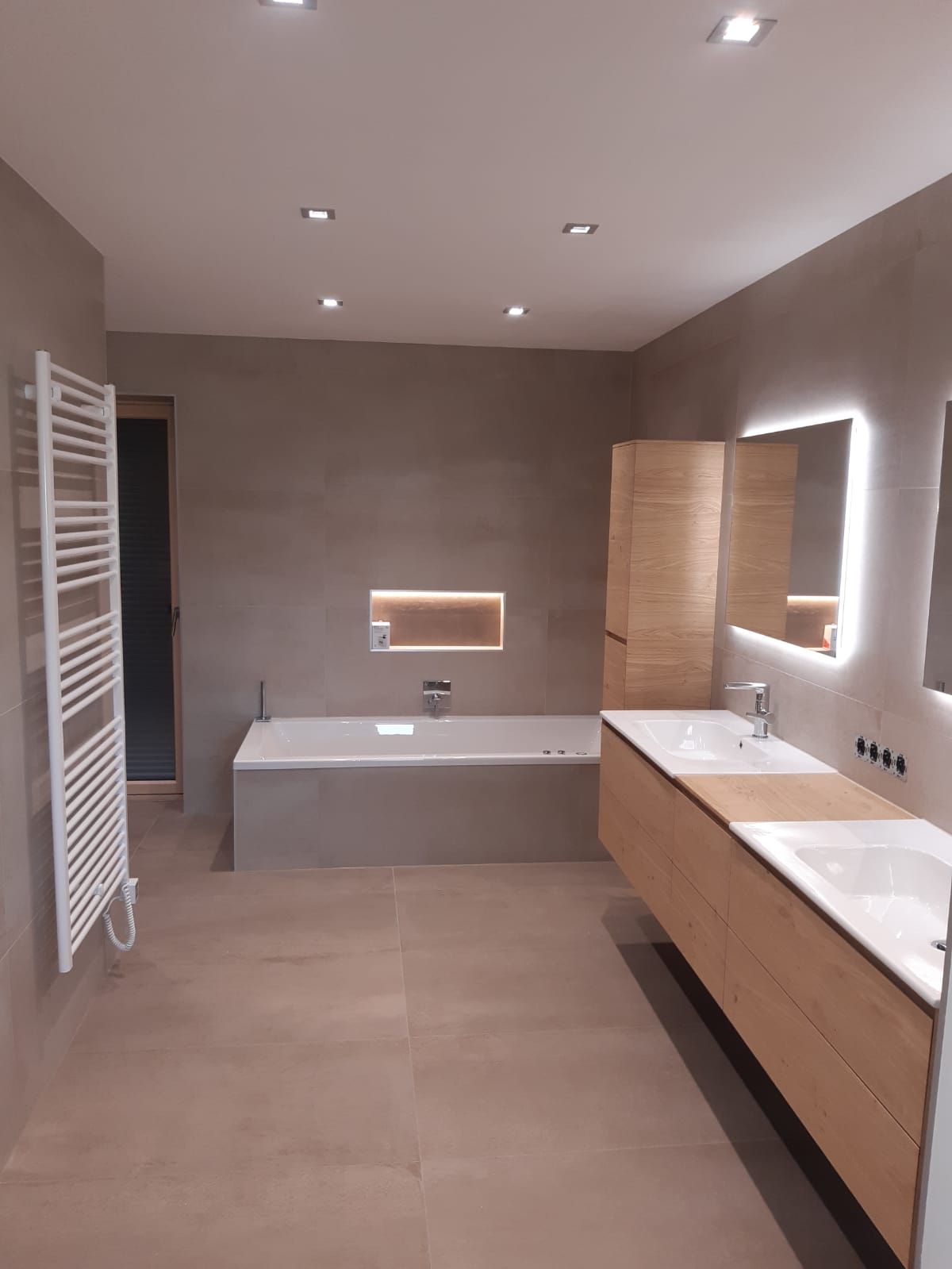 Ein Badezimmer mit zwei Waschbecken, einer Badewanne und einem Spiegel.