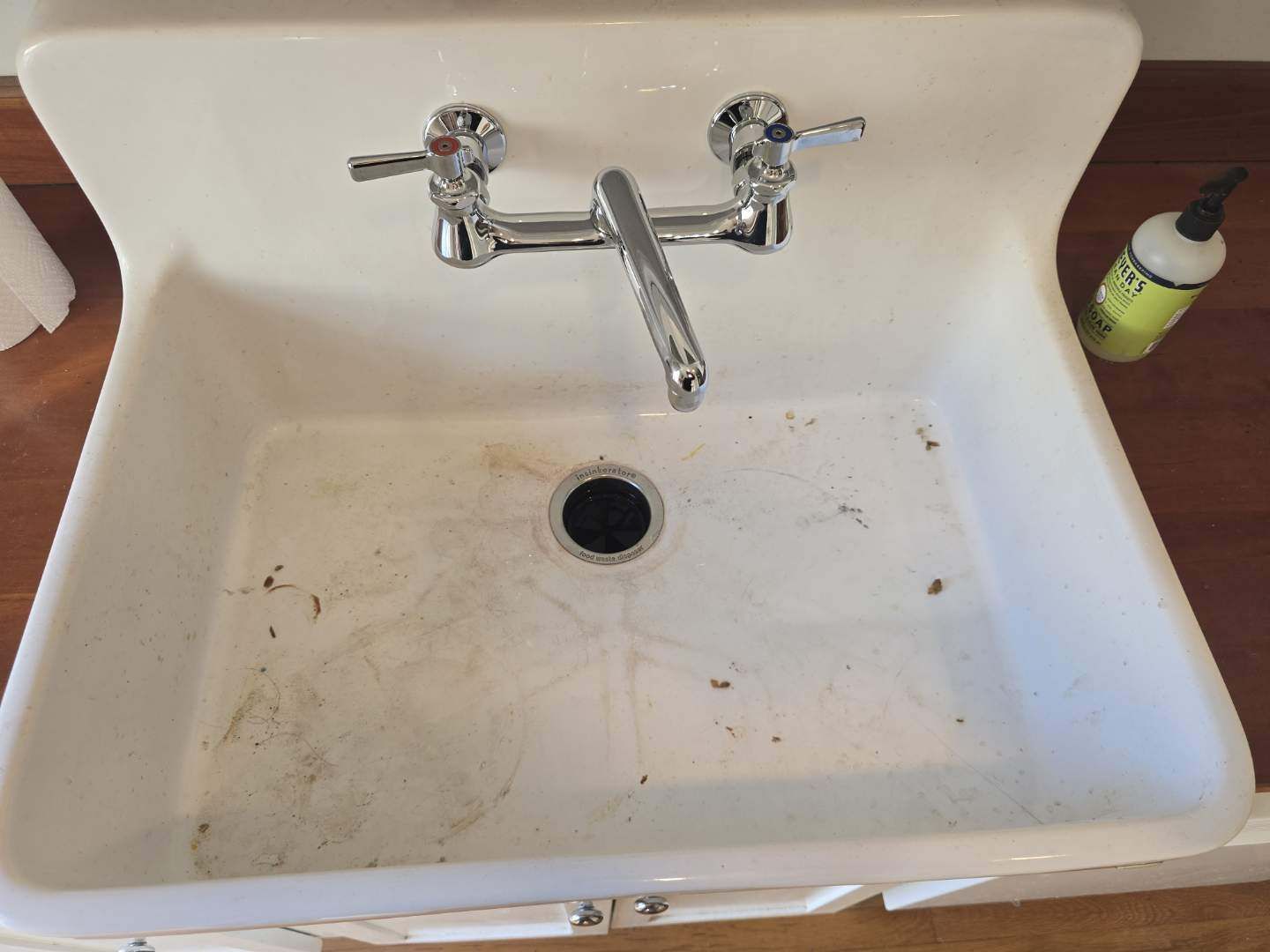 A dirty toilet with the lid open in a bathroom.