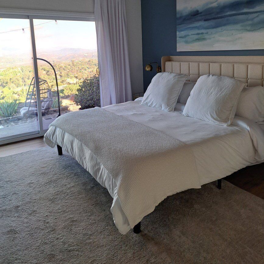 A bedroom with a large bed and a sliding glass door.