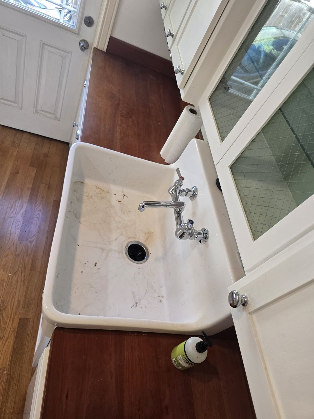 A kitchen sink with a faucet and a paper towel on the counter.