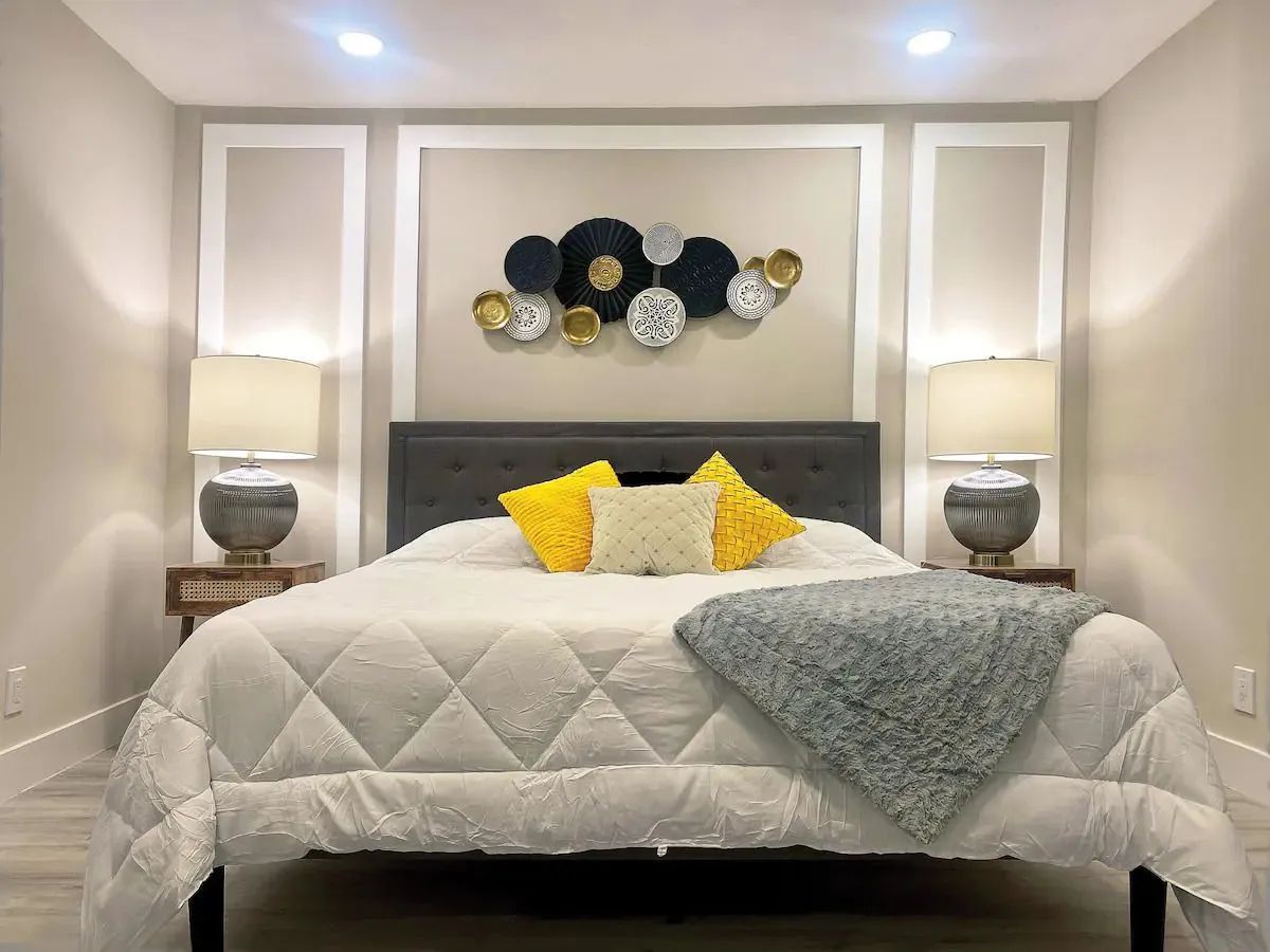 A living room with a couch , chairs , a flat screen tv and a ceiling fan.