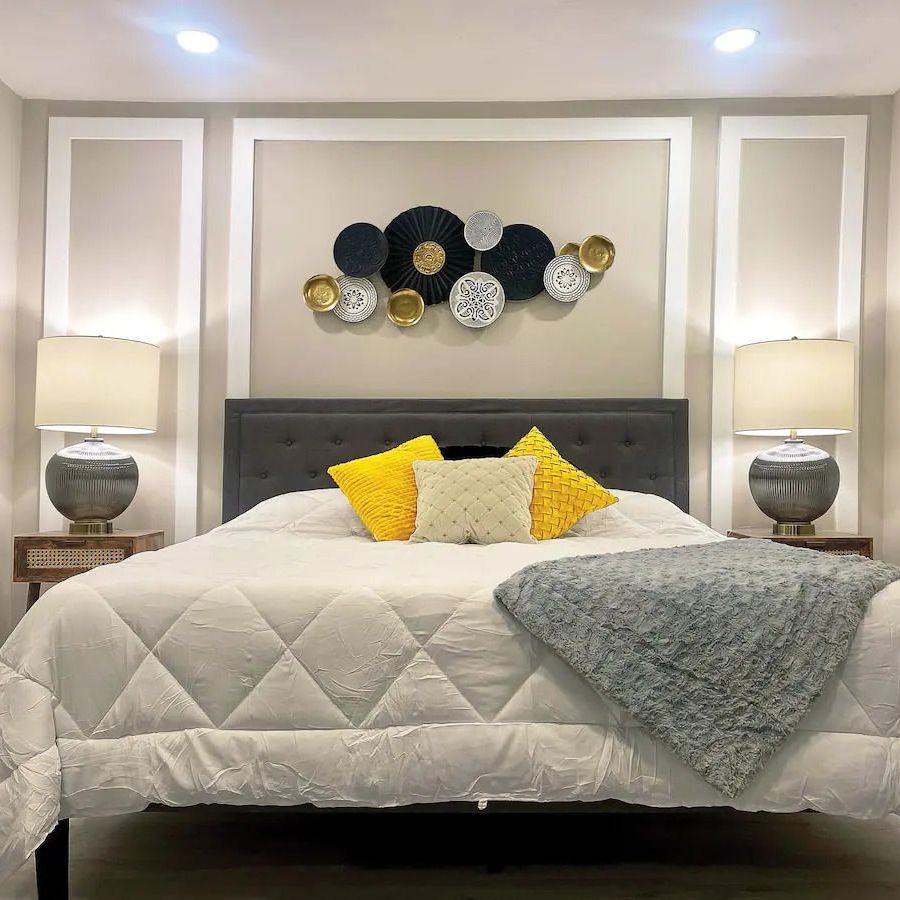 A bedroom with a large bed and two lamps