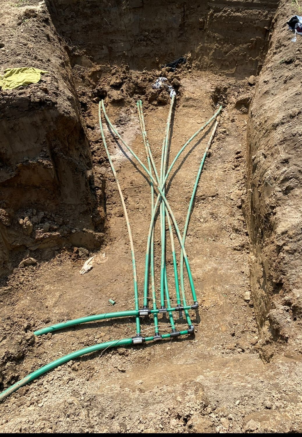 A cutaway view shows a geothermal heat pump system installed underground beside a modern house.