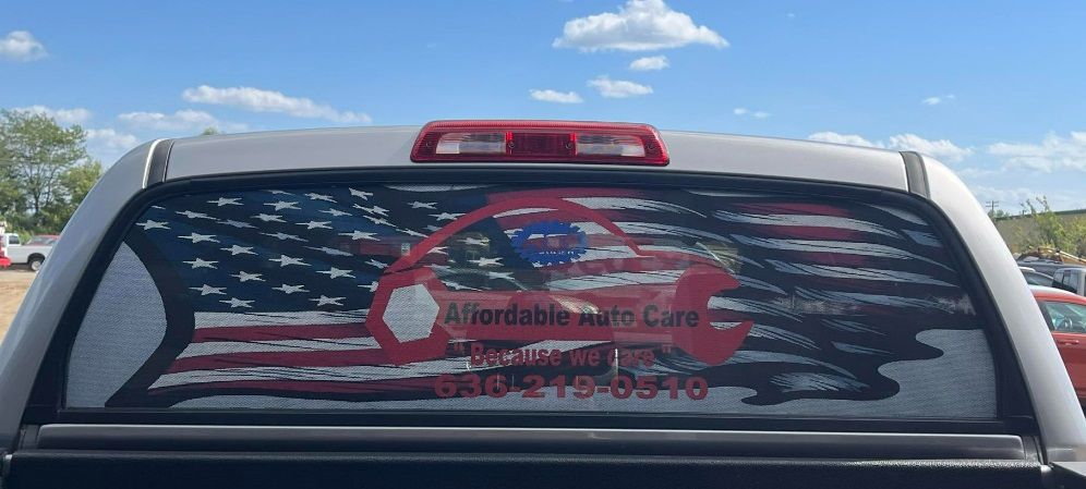 The back window of a truck with an american flag on it.