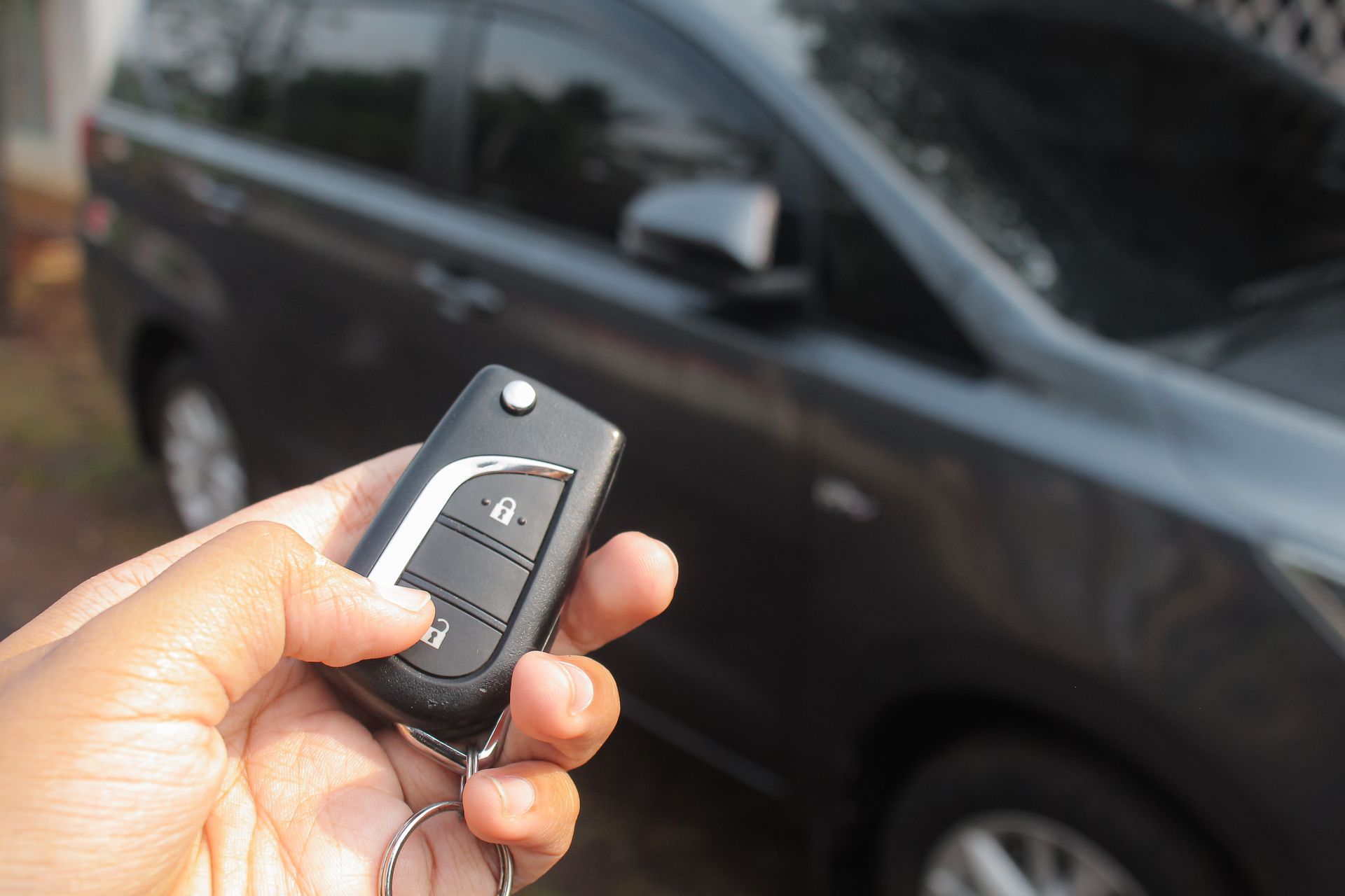 A person is holding a car key in their hand.