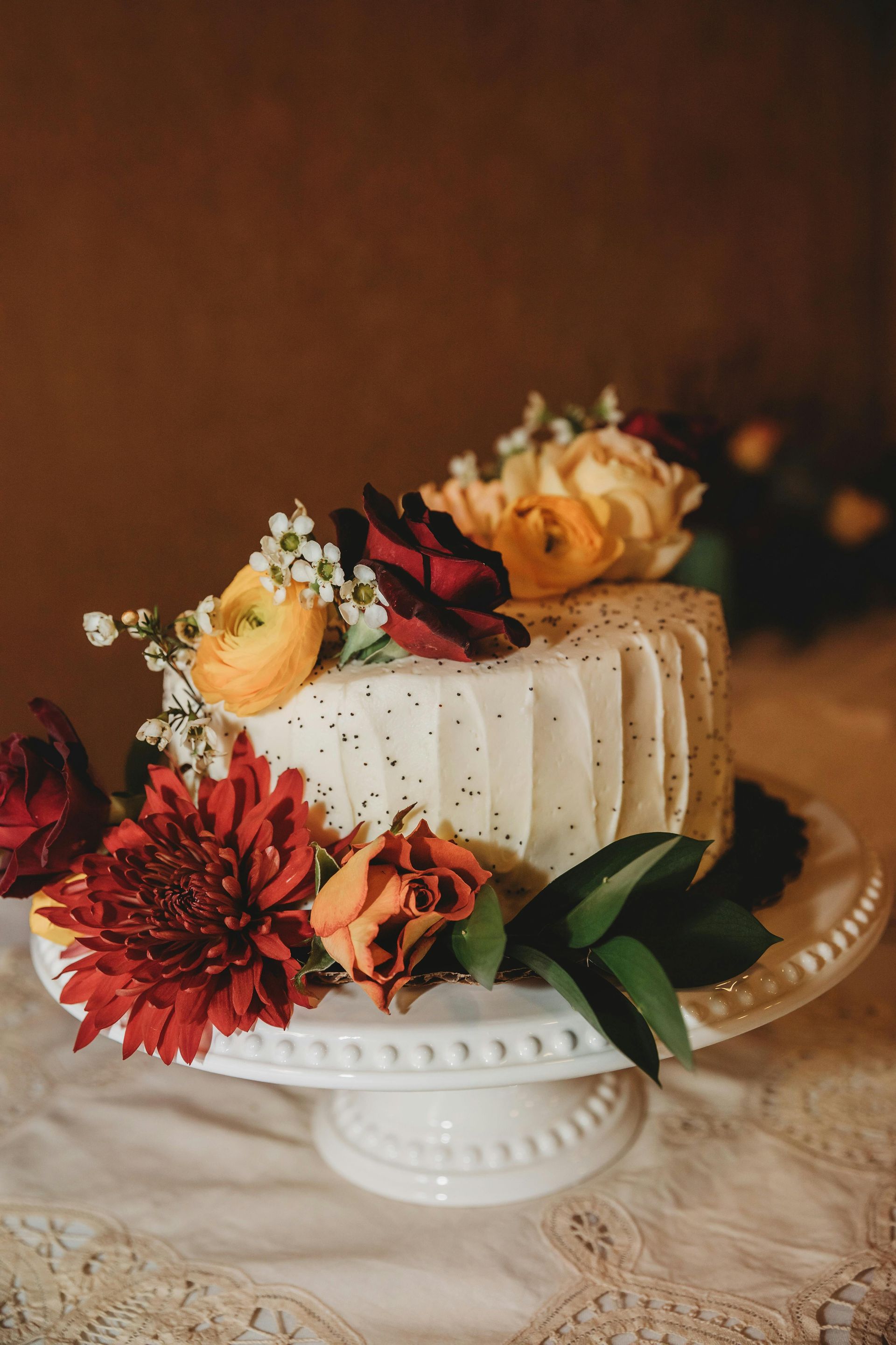 A wedding cake with flowers on top of it on a table.