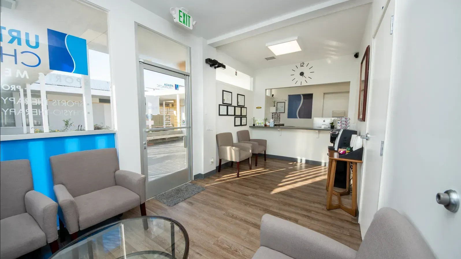 Reception area with chairs, front desk, and doorway to the outside.