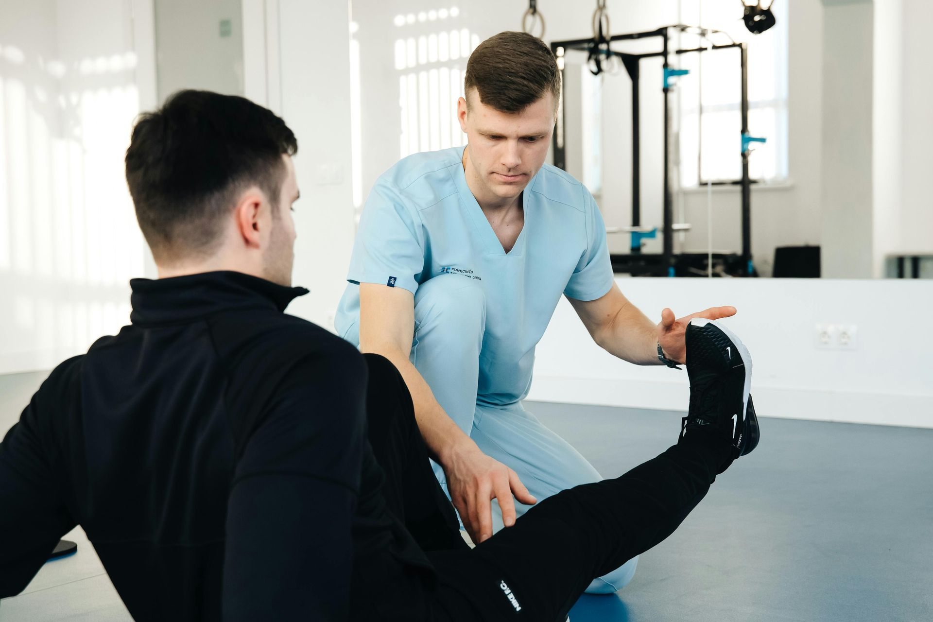 Physical therapist stretching a patient’s leg in a bright clinic